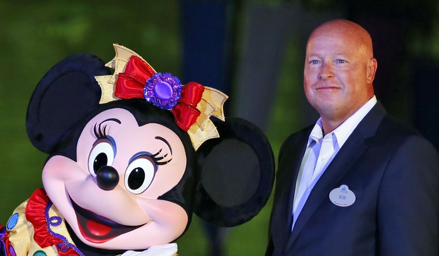FILE - Chairman of Walt Disney Parks and Resorts Bob Chapek poses with Minnie Mouse during a ceremony at the Hong Kong Disneyland, as they celebrate the Hong Kong Disneyland&#39;s 10th anniversary on Sept. 11, 2015. The Walt Disney Company announced late Sunday, Nov. 20, 2022, that former CEO Bob Iger will return to head the company for two years in a move that stunned the entertainment industry.  Disney said in a statement that Chapek, who succeeded Iger in 2020, had stepped down from the position.  (AP Photo/Kin Cheung, File)
