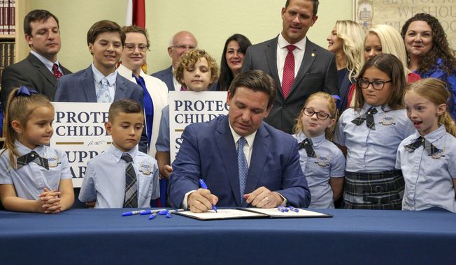 Florida Gov. Ron DeSantis signs the Parental Rights in Education bill at Classical Preparatory school, on March 28, 2022, in Shady Hills, Fla. The Walt Disney Company announced late Sunday, Nov. 20, 2022, that former CEO Bob Iger will return to head the company for two years in a move that stunned the entertainment industry. Disney said in a statement that Bob Chapek, who succeeded Iger in 2020, had stepped down from the position. Chapek faced blowback early this year for not using Disney&#x27;s vast influence in Florida to quash the Republican bill that would prevent teachers from instructing early grades on LGBTQ issues.  (Douglas R. Clifford/Tampa Bay Times via AP, File)
