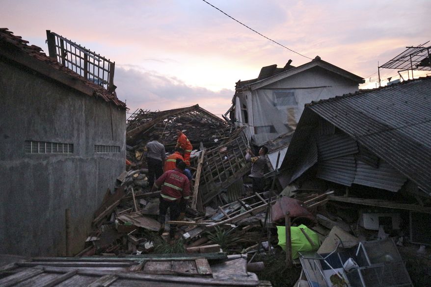 Rescuers search for survivors at the ruins of houses damaged by an earthquake in Cianjur, West Java, Indonesia, Monday, Nov. 21, 2022. The strong, shallow earthquake toppled buildings and collapsed walls on Indonesia&#x27;s densely populated main island of Java on Monday, killing a number of people and injuring hundreds as people rushed into the streets, some covered in blood and white debris. (AP Photo/Rangga Firmansyah)