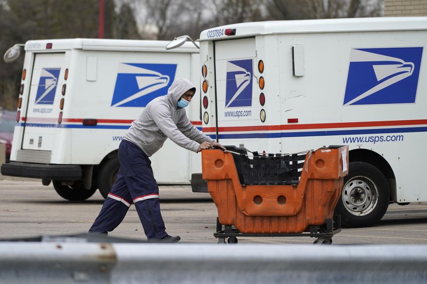 A United States Postal Service employee works outside a post office in Wheeling, Ill., Dec. 3, 2021. (AP Photo/Nam Y. Huh) **FILE**