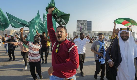 Fans of Saudi Arabia celebrate their team&#39;s 2-1 victory over Argentina in a World Cup group C soccer match, outside the Lusail Stadium in Lusail Qatar, Tuesday, Nov. 22, 2022. (AP Photo/Andre Penner)