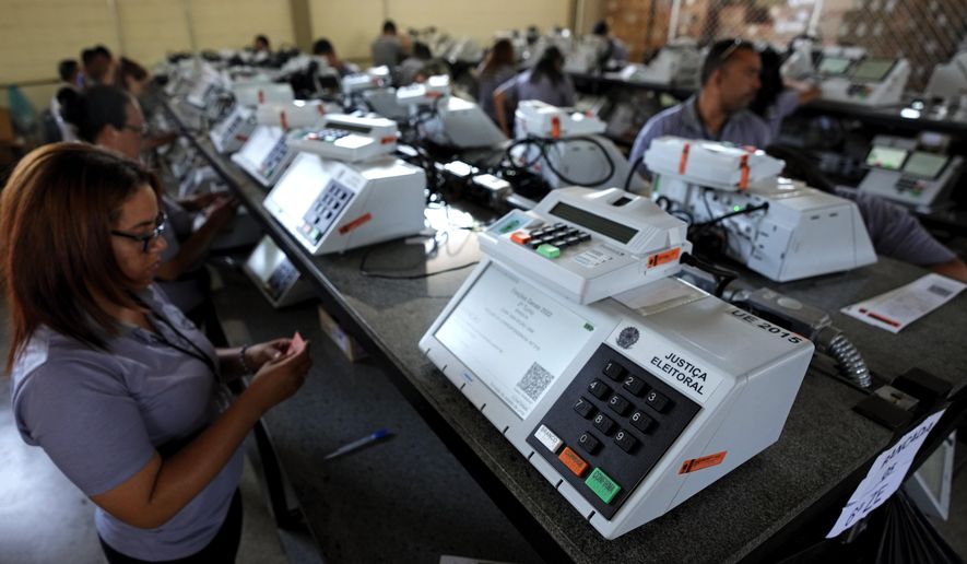 Electoral Court employees work on the final stage of sealing electronic voting machines in preparation for the general election run-off in Brasilia, Brazil, Oct. 19, 2022, ahead of the Oct. 30 second round vote. Valdemar Costa, president of the ruling Liberal Party, is calling on the electoral authority to annul votes cast on more than half of electronic voting machines used in the Oct. 30 election, citing a software bug. (AP Photo/Eraldo Peres, File)
