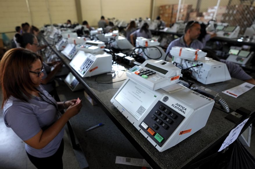 Electoral Court employees work on the final stage of sealing electronic voting machines in preparation for the general election run-off in Brasilia, Brazil, Oct. 19, 2022, ahead of the Oct. 30 second round vote. Valdemar Costa, president of the ruling Liberal Party, is calling on the electoral authority to annul votes cast on more than half of electronic voting machines used in the Oct. 30 election, citing a software bug. (AP Photo/Eraldo Peres, File)
