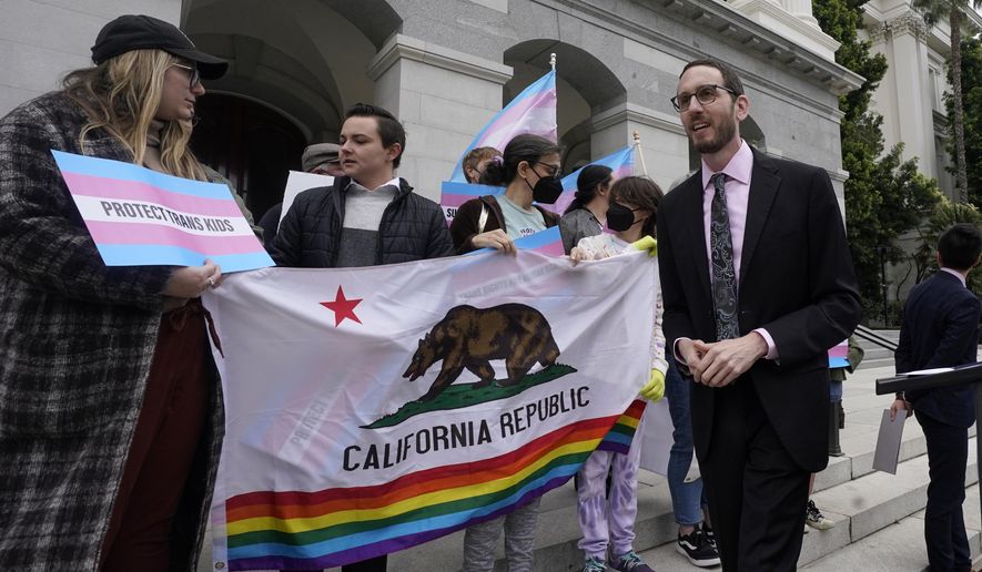 FILE - State Sen. Scott Wiener, D-San Francisco, right, prepares to announce his proposed measure to provide legal refuge to displaced transgender youth and their families during a news conference in Sacramento, Calif., Thursday, March 17, 2022. After the Nov. 8 election several newly elected lawmakers will join Wiener and other members of the LGBTQ caucus which will now make up 10% of the California state Legislature. (AP Photo/Rich Pedroncelli, File)
