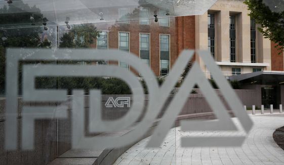 The U.S. Food and Drug Administration building stands behind an FDA logo at a bus stop on the agency&#39;s campus on Aug. 2, 2018, in Silver Spring, Md. The U.S. health regulators on Tuesday, Nov. 22, 2022, have approved the first gene therapy for hemophilia, a $3.5 million treatment that paves the way for new options in treating the blood-clotting disorder. (AP Photo/Jacquelyn Martin, File)