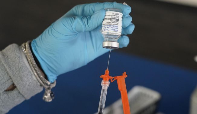A Jackson-Hinds Comprehensive Health Center nurse loads a syringe with a Moderna COVID-19 booster vaccine at an inoculation station next to Jackson State University in Jackson, Miss., Friday, Nov. 18, 2022. Moderna recently announced early evidence that its updated booster induced BQ.1.1-neutralizing antibodies. (AP Photo/Rogelio V. Solis)