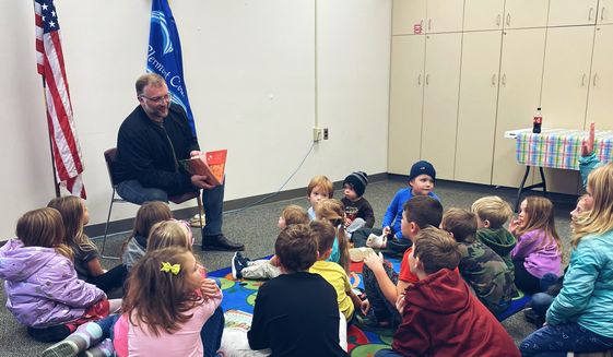 The Rev. Michael Foster of East River Church in Batavia, Ohio, reads from “The King and the Dragon” to children at the local Clermont County Public Library branch. Photo courtesy of Michael Foster; used with permission.