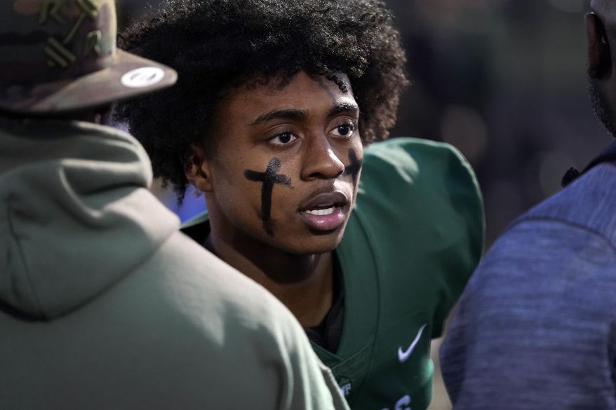 West Bloomfield running back Ralph Rogers, wearing eye black in the form of crosses on each cheek, stands on the sideline before a game against Eisenhower, Friday, Oct. 21, 2022, in West Bloomfield, Mich. (AP Photo/Carlos Osorio)