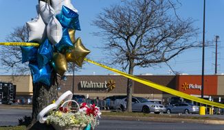 Flowers and balloons have been placed near the scene of a mass shooting at a Walmart, Wednesday, Nov. 23, 2022, in Chesapeake, Va. A Walmart manager opened fire on fellow employees in the break room of the Virginia store, killing several people in the country’s second high-profile mass shooting in four days, police and witnesses said Wednesday.  (AP Photo/Alex Brandon)