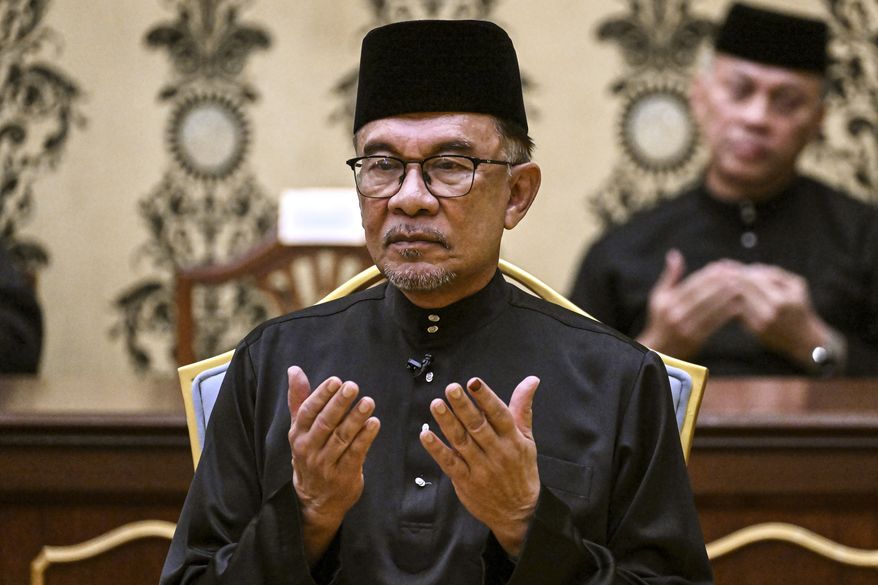 Malaysia&#39;s newly appointed Prime Minister Anwar Ibrahim offers prayers after taking the oath during the swearing-in ceremony at the National Palace in Kuala Lumpur, Malaysia, Thursday, Nov. 24, 2022. Malaysia&#39;s king on Thursday named Anwar as the country&#39;s prime minister, ending days of uncertainty after the divisive general election produced a hung Parliament. (Mohd Rasfan/Pool Photo via AP)