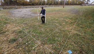 A member of a team affiliated with the National Park Service uses ground-penetrating radar in hopes of detecting what is beneath the soil while searching for over 80 Native American children buried at the former Genoa Indian Industrial School, Thursday, Oct. 27, 2022, in Genoa, Neb. For decades the location of the student cemetery has been a mystery, lost over time after the school closed in 1931 and memories faded of the once-busy campus that sprawled over 640 acres in the tiny community of Genoa. (AP Photo/Charlie Neibergall)