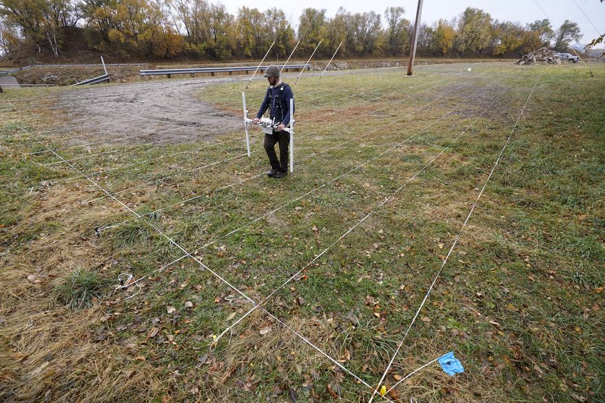 A member of a team affiliated with the National Park Service uses ground-penetrating radar in hopes of detecting what is beneath the soil while searching for over 80 Native American children buried at the former Genoa Indian Industrial School, Thursday, Oct. 27, 2022, in Genoa, Neb. For decades the location of the student cemetery has been a mystery, lost over time after the school closed in 1931 and memories faded of the once-busy campus that sprawled over 640 acres in the tiny community of Genoa. (AP Photo/Charlie Neibergall)