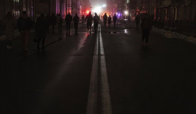 People walk at the city center which lost electrical power after yesterday&#x27;s Russian rocket attack in Kyiv, Ukraine, Thursday, Nov. 24, 2022. (AP Photo/Evgeniy Maloletka)