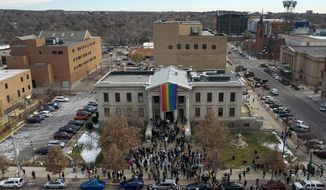 In this aerial image taken with a drone, a rainbow flag is unfurled at City Hall Wednesday, Nov. 23, 2022, in Colorado Springs, Colo. With a growing and diversifying population, the city nestled at the foothills of the Rockies is a patchwork of disparate social and cultural fabrics. But last weekend’s shooting has raised uneasy questions about the lasting legacy of cultural conflicts that caught fire decades ago and gave Colorado Springs a reputation as a cauldron of religion-infused conservatism, where LGBTQ people didn&#x27;t fit in with the most vocal community leaders&#x27; idea of family values (AP Photo/Brittany Peterson)