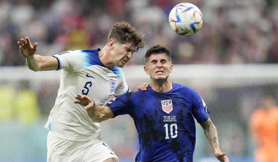 England&#39;s John Stones vies for the ball with Christian Pulisic of the United States, right, during the World Cup group B soccer match between England and The United States, at the Al Bayt Stadium in Al Khor , Qatar, Friday, Nov. 25, 2022. (AP Photo/Luca Bruno)