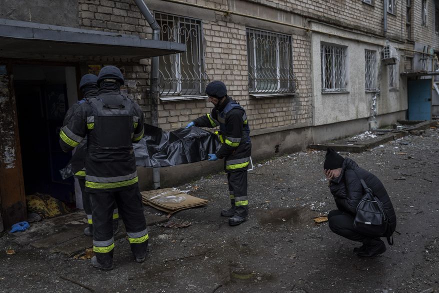 Lilia Kristenko, 38, cries as city responders collect the dead body of her mother Natalia Kristenko in Kherson, southern Ukraine, Friday, Nov. 25, 2022. Natalia Kristenko&#x27;s dead body lay covered in a blanket in the doorway of her apartment building for hours overnight. The 62-year-old woman had walked outside her home with her husband Thursday evening after drinking tea when the building was struck. Kristenko was killed instantly from a wound to the head. Her husband died hours later in the hospital from internal bleeding. (AP Photo/Bernat Armangue)