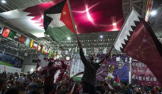 Palestinian soccer fans wave Qatari and Palestinian flags as they watch a live broadcast of the 2022 World Cup opening match between Qatar and Ecuador, at a covered gymnasium in Gaza City, on Nov. 20, 2022. For a brief moment after Saudi Arabia&#39;s Salem Aldawsari fired a soccer ball from just inside the penalty box into the back of the net to seal a win against Argentina, Arabs across the divided Middle East found something to celebrate. (AP Photo/Fatima Shbair, File)