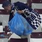 Japan supporters clean the stands at the end of the World Cup group E soccer match between Germany and Japan, at the Khalifa International Stadium in Doha, Qatar, Wednesday, Nov. 23, 2022. Japan won 2-1.(AP Photo/Eugene Hoshiko)