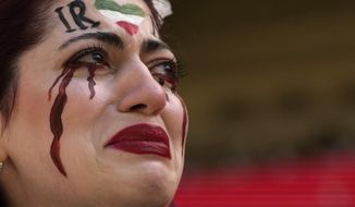 An Iranian woman, name not given, breaks into tears after a member of security seized her flag reading &amp;quot;Woman Life Freedom&amp;quot; before the start of the World Cup group B soccer match between Wales and Iran, at the Ahmad Bin Ali Stadium in Al Rayyan, Qatar, Friday, Nov. 25, 2022. (AP Photo/Alessandra Tarantino)