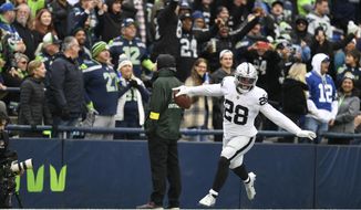 Las Vegas Raiders running back Josh Jacobs (28) celebrates after scoring a touchdown during the first half of an NFL football game against the Seattle Seahawks Sunday, Nov. 27, 2022, in Seattle. (AP Photo/Caean Couto)