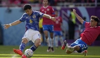 Costa Rica&#39;s Yeltsin Tejeda, right, tries to block a shot from Japan&#39;s Wataru Endo during the World Cup, group E soccer match between Japan and Costa Rica, at the Ahmad Bin Ali Stadium in Al Rayyan , Qatar, Sunday, Nov. 27, 2022. (AP Photo/Ariel Schalit)
