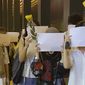 Protesters hold up blank white papers during a commemoration for victims of a recent Urumqi deadly fire in Central in Hong Kong, Monday, Nov. 28, 2022. Students in Hong Kong chanted “oppose dictatorship” in a protest against China’s anti-virus controls after crowds in mainland cities called for President Xi Jinping to resign in the biggest show of opposition to the ruling Communist Party in decades. (AP Photo/Zen Soo)