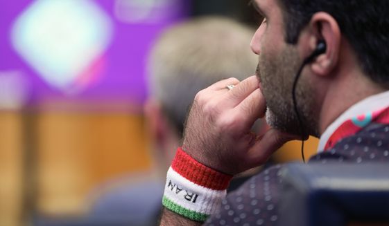 A man wears an Iran arm band during a press conference on the eve of the group B World Cup soccer match between Iran and the United States in Doha, Qatar, Monday, Nov. 28, 2022. (AP Photo/Ashley Landis)