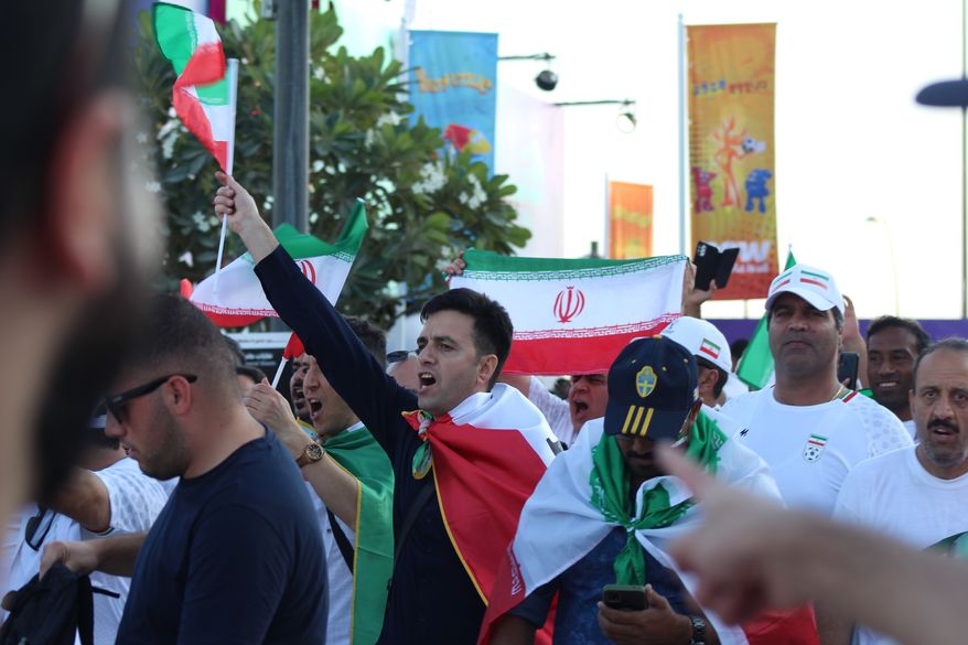 Fans parade down the street in celebration of the Iranian national soccer team&#x27;s victory over Wales at Ahmed bin Ali Stadium in Al Rayyan, Qatar, on Nov. 25. (Hunter Roberts/Special to The Washington Times)