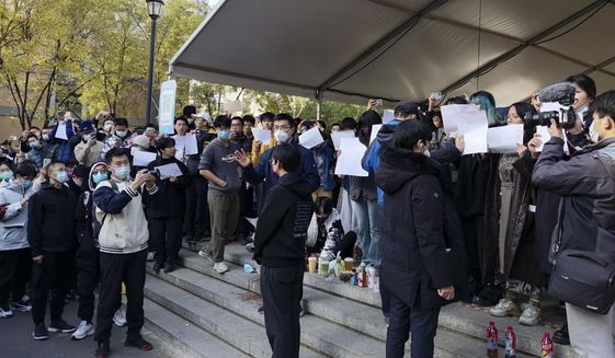 In this photo taken on Sunday, Nov. 27, 2022, students hold up blank papers as they stage a protest at Tsinghua University in Beijing, China. Authorities eased anti-virus rules in scattered areas but affirmed China&#x27;s severe &amp;quot;zero-COVID&amp;quot; strategy Monday after crowds demanded President Xi Jinping resign during protests against controls that confine millions of people to their homes. (AP Photo)