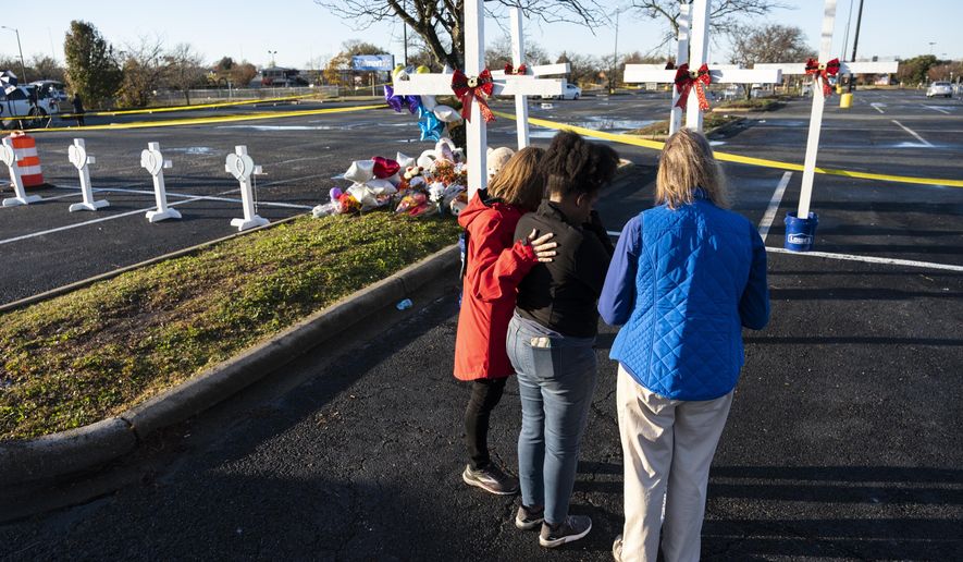 Sheree Perry of Virginia Beach, center, prays with chaplains at a memorial on Friday, Nov. 25, 2022 , for the six killed in a Chesapeake, Va., Walmart mass shooting earlier in the week. (Billy Schuerman/The Virginian-Pilot via AP)