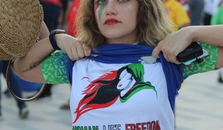 A protester unveils her “Women, Life, Freedom” T-shirt following the Iran vs. Wales match in Ahmed Bin Ali Stadium in Al Rayyan on Nov. 25. (Hunter Roberts/Special to The Washington Times)