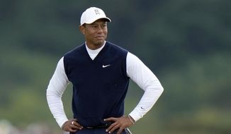 Tiger Woods, of the United States, stands on the 11th hole during the first round of the British Open golf championship on the Old Course at St. Andrews, Scotland, on July 14, 2022. Woods was out before he was officially back, withdrawing Monday, Nov. 28, 2022, from his Hero World Challenge with plantar fasciitis in his right foot. (AP Photo/Alastair Grant, File) **FILE**