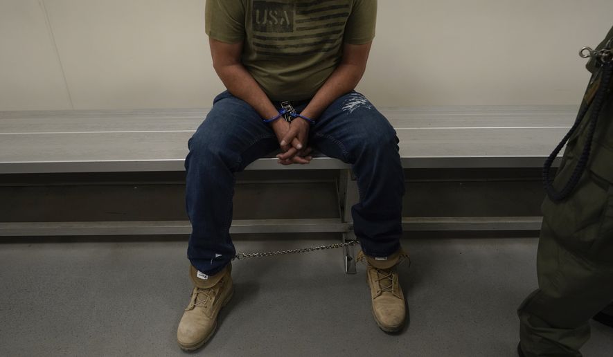 An immigrant considered a threat to public safety and national security waits to be processed by U.S. Immigration and Customs Enforcement agents at the ICE Metropolitan Detention Center in Los Angeles, after an early morning raid, June 6, 2022. (AP Photo/Damian Dovarganes, File)