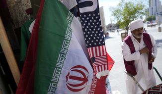 An Iranian flag and a scarf depicting U.S. flag are sold at the Souq Waqif Market in Doha, Qatar, Tuesday, Nov. 29, 2022. (AP Photo/Eugene Hoshiko)