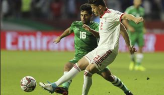 FILE — Voria Ghafouri, right, fights for the ball with Iraqi midfielder Hussein Ali, during the AFC Asian Cup soccer match in Dubai, United Arab Emirates, Jan. 16, 2019. Iranian authorities said Ghafouri, a former member of the national soccer team arrested last week over his criticism of the government, has been released on bail. The announcement Tuesday, Nov. 29, 2022, came hours before Iran was set to play the U.S. at the World Cup in a match that authorities are heavily promoting as they grapple with nationwide protests that are well into their third month. (AP Photo/Kamran Jebreili, File)