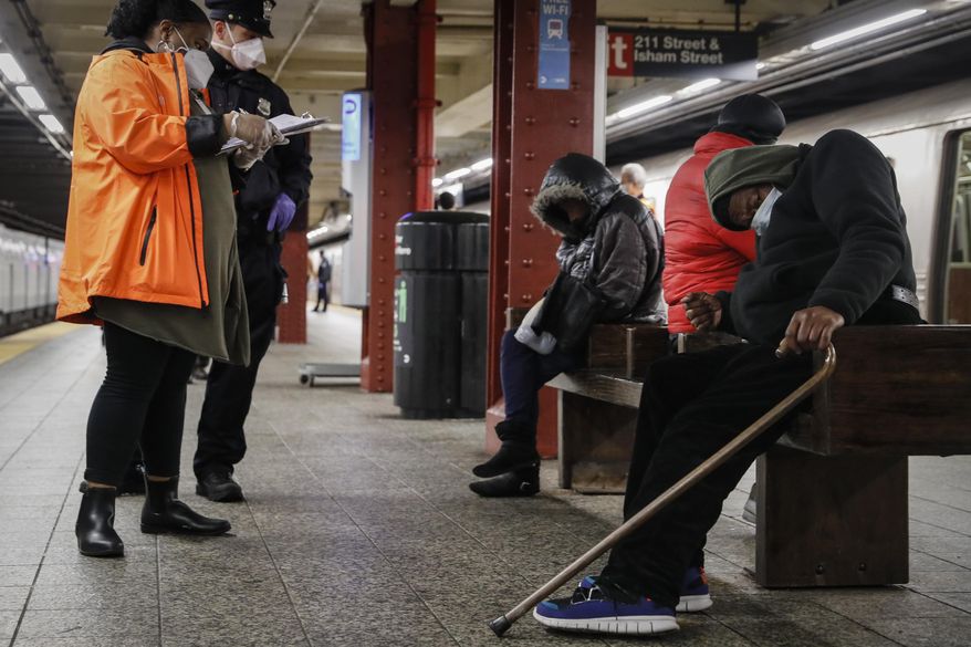 A homeless outreach worker and New York police officer assist passengers found sleeping on subway cars at the 207th Street A-train station, Thursday, April 30, 2020, in the Manhattan borough of New York. In New York City's latest effort to address a mental health crisis on its streets and subways, Mayor Eric Adams announced Tuesday, Nov. 29, 2022, that authorities would more aggressively intervene to help people in need of treatment, saying there was "a moral obligation" to do so, even if it means providing care to those who don't ask for it. (AP Photo/John Minchillo, File)
