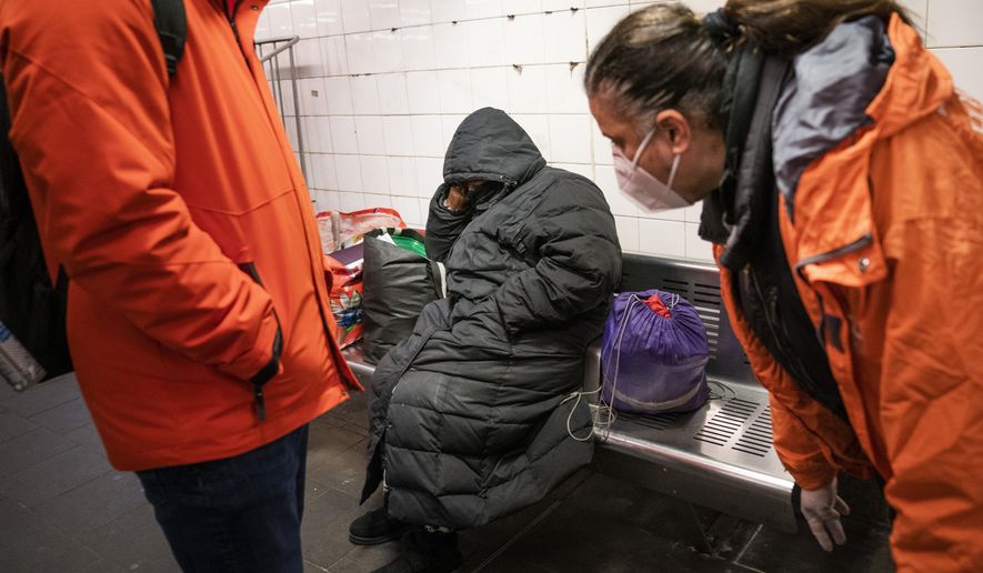 FILE - Homeless Outreach personnel reach out to a person sleeping on a bench in the Manhattan subway system, Monday, Feb. 21, 2022, in New York. In New York City&#39;s latest effort to address a mental health crisis on its streets and subways, Mayor Eric Adams announced Tuesday, Nov. 29, that authorities would more aggressively intervene to help people in need of treatment, saying there was &amp;quot;a moral obligation&amp;quot; to do so, even if it means providing care to those who don&#39;t ask for it. (AP Photo/John Minchillo, File)