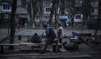 Residents do repair works on a recently damaged building during a Russian strike in the southern city of Kherson, Ukraine, Sunday, Nov. 27, 2022. Shelling by Russian forces struck several areas in eastern and southern Ukraine overnight as utility crews continued a scramble to restore power, water and heating following widespread strikes in recent weeks, officials said Sunday. (AP Photo/Bernat Armangue)