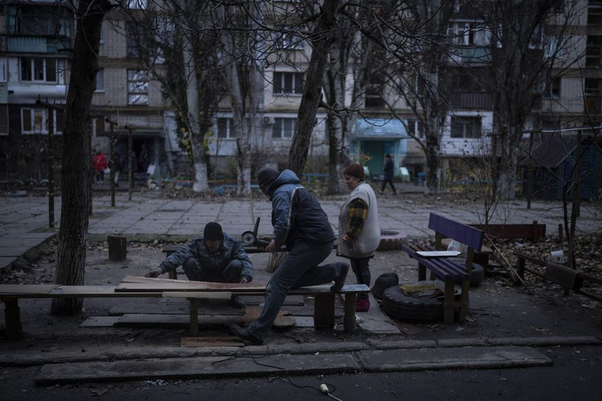 Residents do repair works on a recently damaged building during a Russian strike in the southern city of Kherson, Ukraine, Sunday, Nov. 27, 2022. Shelling by Russian forces struck several areas in eastern and southern Ukraine overnight as utility crews continued a scramble to restore power, water and heating following widespread strikes in recent weeks, officials said Sunday. (AP Photo/Bernat Armangue)