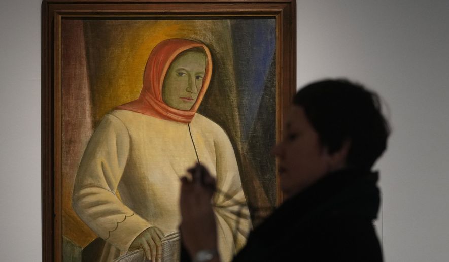 A woman takes photos next to the painting by Ukrainian artist Vasyl Sedliar called &#39;Portrait of Oksana Pavlenko&#39; during the inauguration of the Ukraine art exposition at the Thyssen-Bornemisza museum in Madrid, Spain, Monday, Nov. 28, 2022. Against a backdrop of Russian attacks, border closures and a nail-biting journey across Europe, Madrid&#39;s Thyssen-Bornemisza National Museum has teamed up with Kyiv&#39;s National Art Museum of Ukraine to secretly bring dozens of Ukrainian 20th century avant garde artworks by road to the Spanish capital for a unique exhibition and statement of support for the war-torn country. (AP Photo/Paul White)