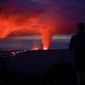A man looks on as lava erupts from Hawaii&#39;s Mauna Loa volcano Wednesday, Nov. 30, 2022, near Hilo, Hawaii. (AP Photo/Gregory Bull)