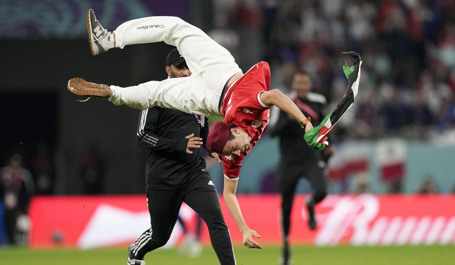 A pitch invader jumps during a World Cup group D soccer match between Tunisia and France at the Education City Stadium in Al Rayyan, Qatar, Wednesday, Nov. 30, 2022. (AP Photo/Martin Meissner)
