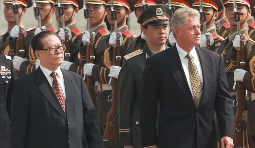 Then U.S. President Bill Clinton, right, and the then Chinese President Jiang Zemin, left, review Chinese troops during arrival ceremonies at east the plaza of the Great Hall of the People in Beijing, June 27, 1998.  (AP Photo/David Longstreath, File)