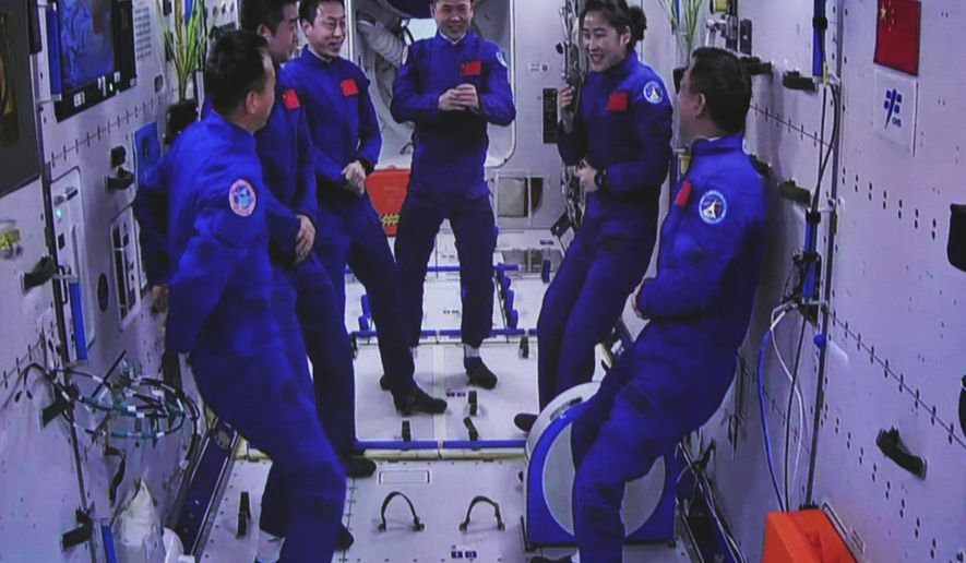 In this photo released by Xinhua News Agency, an image captured off a screen at the Jiuquan Satellite Launch Center in northwest China shows the Shenzhou-15 and Shenzhou-14 crew chatting after a historic gathering in space on Wednesday, Nov. 30, 2022. Three Chinese astronauts docked early Wednesday with their country&#39;s space station, where they will overlap for several days with the three-member crew already onboard and expand the facility to its maximum size. (Guo Zhongzheng/Xinhua via AP)