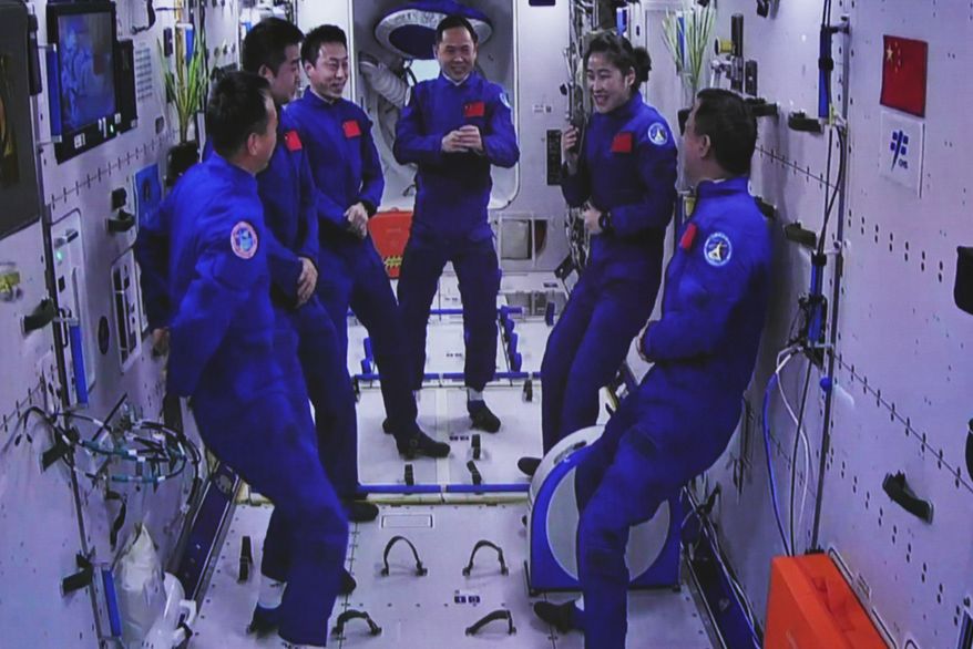 In this photo released by Xinhua News Agency, an image captured off a screen at the Jiuquan Satellite Launch Center in northwest China shows the Shenzhou-15 and Shenzhou-14 crew chatting after a historic gathering in space on Wednesday, Nov. 30, 2022. Three Chinese astronauts docked early Wednesday with their country&#x27;s space station, where they will overlap for several days with the three-member crew already onboard and expand the facility to its maximum size. (Guo Zhongzheng/Xinhua via AP)