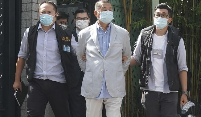 Hong Kong media tycoon Jimmy Lai, center, who founded local newspaper Apple Daily, is arrested by police officers at his home in Hong Kong, on Aug. 10, 2020. The trial of a Hong Kong newspaper publisher who was arrested in a crackdown on a pro-democracy movement was postponed on Thursday, Dec. 1, 2022, after the territory&#x27;s leader asked China to effectively block him from hiring a British defense lawyer. (AP Photo/File)