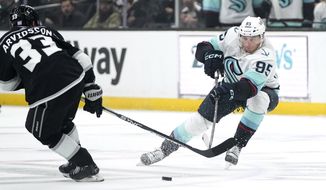 Seattle Kraken left wing Andre Burakovsky, right, passes the puck past Los Angeles Kings right wing Viktor Arvidsson during the first period of an NHL hockey game Tuesday, Nov. 29, 2022, in Los Angeles. (AP Photo/Mark J. Terrill)