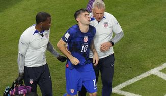 Christian Pulisic of the United States is helped by team doctors after he scoring his side&#39;s opening goal during the World Cup group B soccer match between Iran and the United States at the Al Thumama Stadium in Doha, Qatar, Tuesday, Nov. 29, 2022. (AP Photo/Luca Bruno)