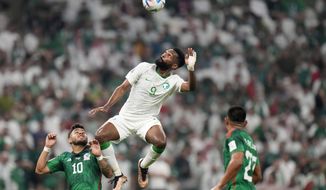 Mexico&#39;s Alexis Vega, left, and Mexico&#39;s Jesus Gallardo, right, watch Saudi Arabia&#39;s Firas Al-Buraikan jumping for the ball during the World Cup group C soccer match between Saudi Arabia and Mexico, at the Lusail Stadium in Lusail, Qatar, Wednesday, Nov. 30, 2022. (AP Photo/Moises Castillo)