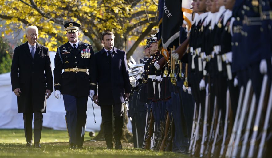 President Joe Biden and French President Emmanuel Macron review the troops with Col. David Rowland, commander of the 3rd U.S. Infantry Regiment, The Old Guard, during a State Arrival Ceremony on the South Lawn of the White House in Washington, Thursday, Dec. 1, 2022. (AP Photo/Andrew Harnik)